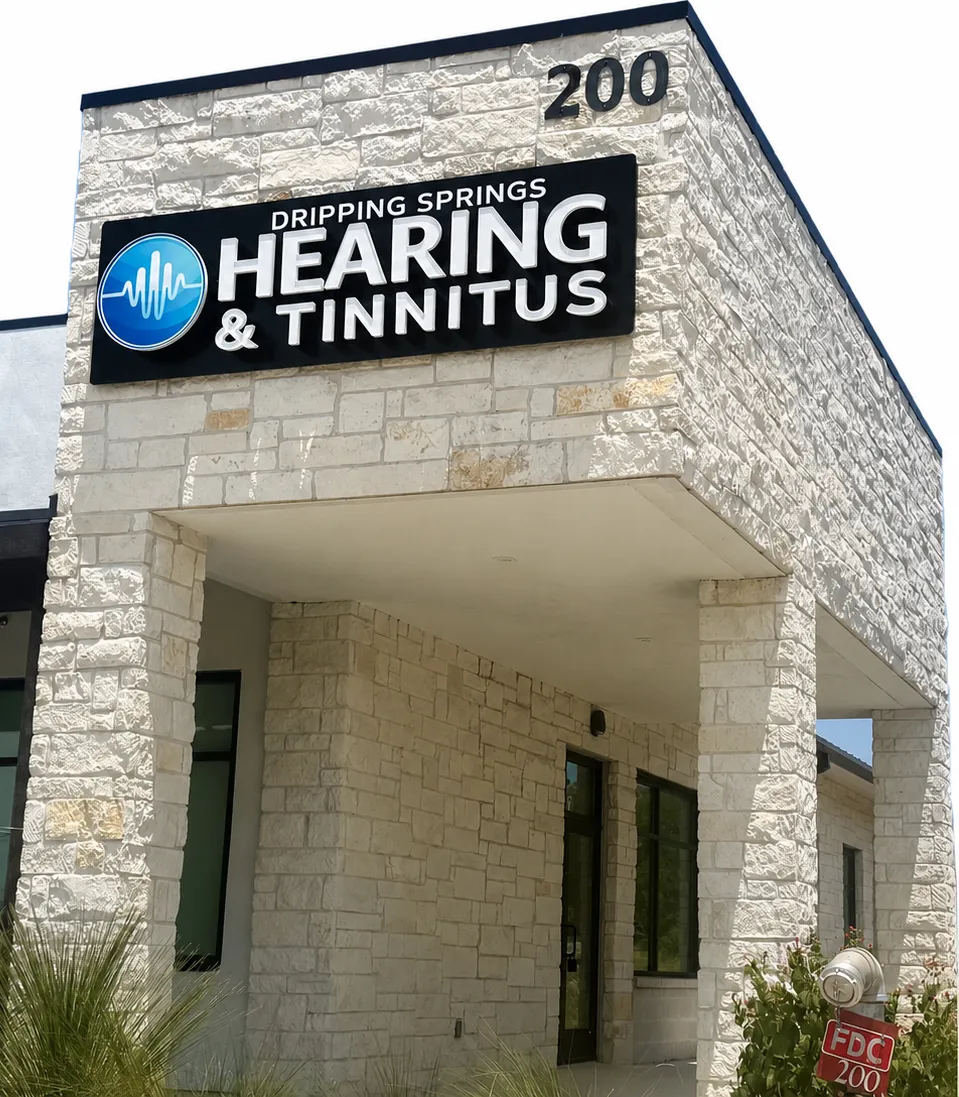The Dripping Springs Hearing & Tinnitus sign on the stone office building, just off Hwy 290