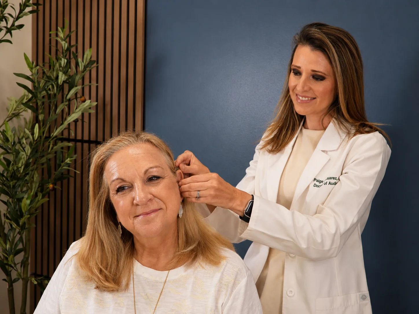 Dr. Paige Juarez fitting a patient's hearing aid